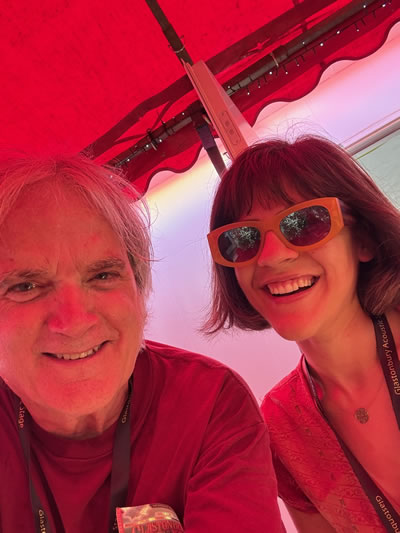 Sid Griffin grinning with newcomer Katya The Artist at Glastonbury 2025 before they shared the stage with Ralph McTell, Oisin Leech, Paul Carrack, Liam Omaonlai of the Hothouse Flowers and others for Not Completely Unknown: the Songs of Bob Dylan